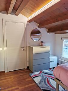 1 dormitorio con cama, tocador y espejo en Mansarda centro storico en Pordenone