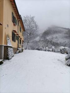 una calle cubierta de nieve frente a un edificio en Welcome in Toscana, en Polcanto