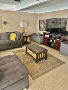 ein Wohnzimmer mit einem Sofa und einem TV in der Unterkunft The Hooper House in Grenada