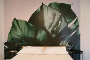 - une chambre ornée d'une grande fresque murale représentant des feuilles vertes dans l'établissement Apartments Toni, à Split