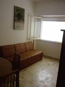 sala de estar con sofá y ventana en Miramar departamento 2 ambientes frente al mar en Miramar