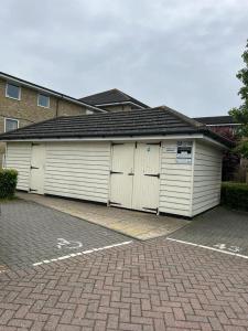 a building with two garage doors in a parking lot at Modern Spacious Gated Two Bedrooms Apartment in Stifford