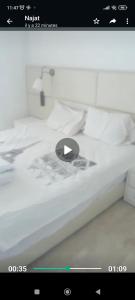 un'immagine di un letto con schermo in bianco e nero di Bel appartement à sania plage vue sur mer a M'diq