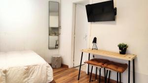 una camera con letto e tavolo con TV a parete di Barcelona Park Güell Estudio a Barcellona