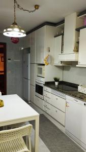 uma cozinha com armários brancos e uma mesa branca em El piso de Sabina em Santander