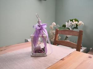 une lanterne en verre avec une étrave violette sur une table dans l'établissement La Tavernetta, à Torriana