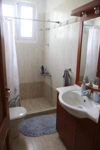 W łazience znajduje się prysznic, umywalka i toaleta. w obiekcie George’s House w mieście Kími
