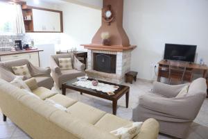 a living room with a couch and a fireplace at George’s House in Kymi