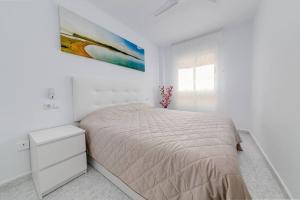 una camera bianca con un letto e un dipinto sul muro di Calle Concordia 86, two bedroom apartment, up to 6 guests, near Del Cura beach,supermarket Mercadona and central bus station a Torrevieja