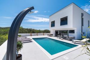 une villa avec une piscine et une maison dans l'établissement Villa Kurnatari, à Jezera