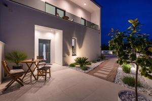 un patio de una casa con mesa y sillas en Villa Kurnatari, en Jezera