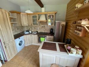 a kitchen with wooden cabinets and a washer and dryer at Czym Chata Bogata in Korbielów +50 photos