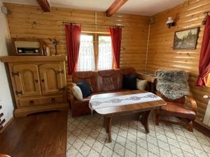 a living room with a couch and a coffee table at Czym Chata Bogata in Korbielów