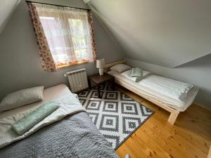 1 dormitorio con 2 camas y ventana en Czym Chata Bogata, en Korbielów