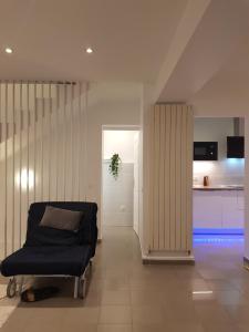 a living room with a couch and a kitchen at Charmante villa proche de la gare et de Paris in Les Pavillons-sous-Bois