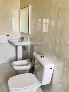 Baño blanco con aseo y lavamanos en Apartamento As Lagoas, en Bueu