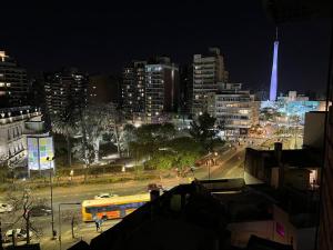 un autobús amarillo conduciendo por una calle de la ciudad por la noche en Larrañaga 2 dorm. Nueva Córdoba en Córdoba