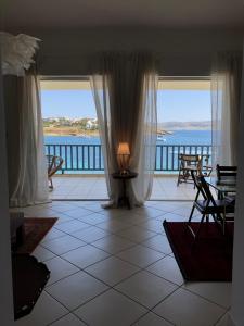 a room with a large window with a view of the water at Pounta Beach House in Sounio