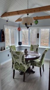 a dining room with a table and chairs and windows at Legend Rock Lodge in South Kingstown