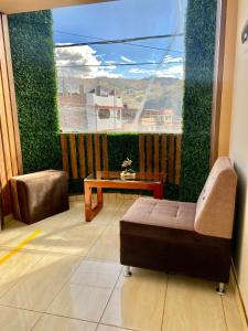 een kamer met een bank en een tafel op een balkon bij HOSPEDAJE ILLARY in Huaraz