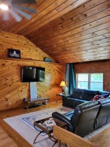 a living room with a couch and a flat screen tv at Legend Rock Lodge in South Kingstown