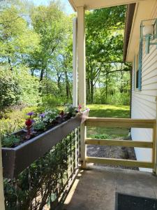 um alpendre com uma caixa de flores ao lado de uma casa em Legend Rock Lodge em South Kingstown