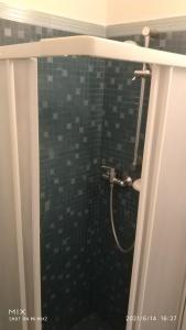 y baño con ducha y pared de azulejos. en Dimora La Chianca, en Marina Serra
