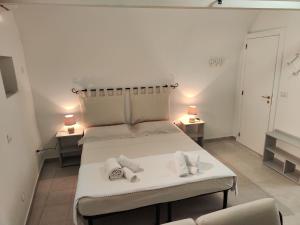 1 dormitorio con 1 cama blanca grande y 2 mesas en Dimora La Chianca, en Marina Serra