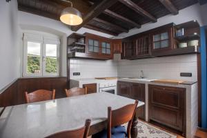 eine Küche mit Tisch und Stühlen und einem Fenster in der Unterkunft 164- Villa della Marchesa - Giardino e Piscina a pochi minuti dal centro di Sestri Levante in Santo Stefano del Ponte