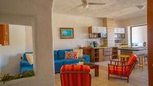 a living room with a blue couch and a kitchen at Condo in Puerto las Hadas in Manzanillo