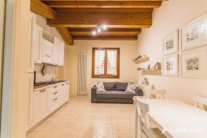 a kitchen and a living room with a couch at Ca' degli Ulivi - Oliva Verde in Creazzo