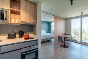 a kitchen and a room with a bed and a table at Almasur Providencia in Santiago
