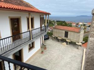 a balcony of a house with a car on a patio at O Casa con vistas en Carnota in Lira