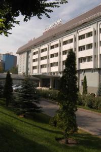 um grande edifício branco com árvores em frente em Astana International Hotel em Almaty