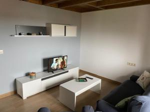 a living room with a couch and a tv at O Casa con vistas en Carnota in Lira