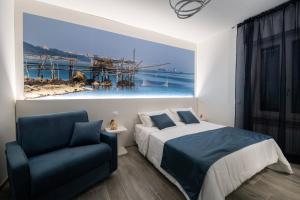 a bedroom with a bed and a blue chair at DOMORA BEDROOMS in Ortona