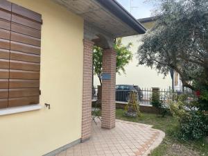 a porch with a brick pillar and a house at La Casa di Zucchero in Classe