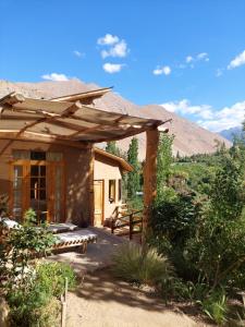 una pérgola de madera en una casa con mesa de picnic en CASAS AMANCAY - Alcohuaz, en Alcoguaz