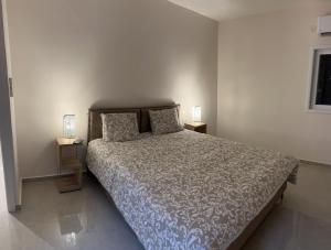 a bedroom with a bed and two lamps on tables at Topnatanya in Netanya