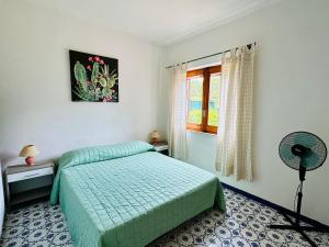 a bedroom with a green bed and a window at Rena Majore in vacanza in Rena Majore