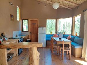 a kitchen and living room with a blue couch at CASAS AMANCAY - Alcohuaz in Alcoguaz