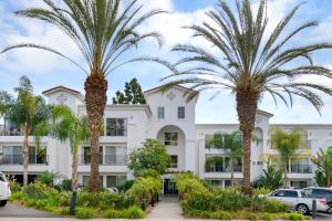 a building with palm trees in front of it at 633 Top Floor Corner Condo inside the gates of the Resort in Encinitas