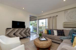 a living room with a couch and a tv at 633 Top Floor Corner Condo inside the gates of the Resort in Encinitas