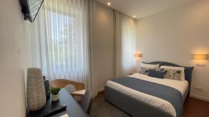 um quarto de hotel com uma cama e uma janela em MyTrip Porto em Matosinhos
