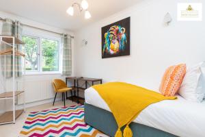um quarto com uma cama com um cobertor amarelo em 4 Bed House Stevenage SG1 Free Parking & Wi-Fi Business & Families Serviced Accommodation by White Orchid Property Relocation em Stevenage