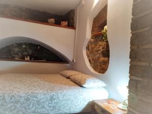 um quarto com uma cama e uma parede de pedra em Estia Bed and Relax em Benevento