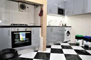 eine Küche mit schwarz-weiß kariertem Boden in der Unterkunft Family Bedroom in Lissabon