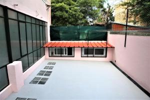 einen leeren Balkon eines rosa Gebäudes mit einem Dach in der Unterkunft Family Bedroom in Lissabon