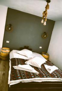 a bedroom with a bed with white sheets and pillows at Voinescu House - Natural Living & Eating in Şimon