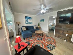 a living room with a blue couch and a ceiling fan at Rock Ridge I. Private and close to everything. in Vero Beach